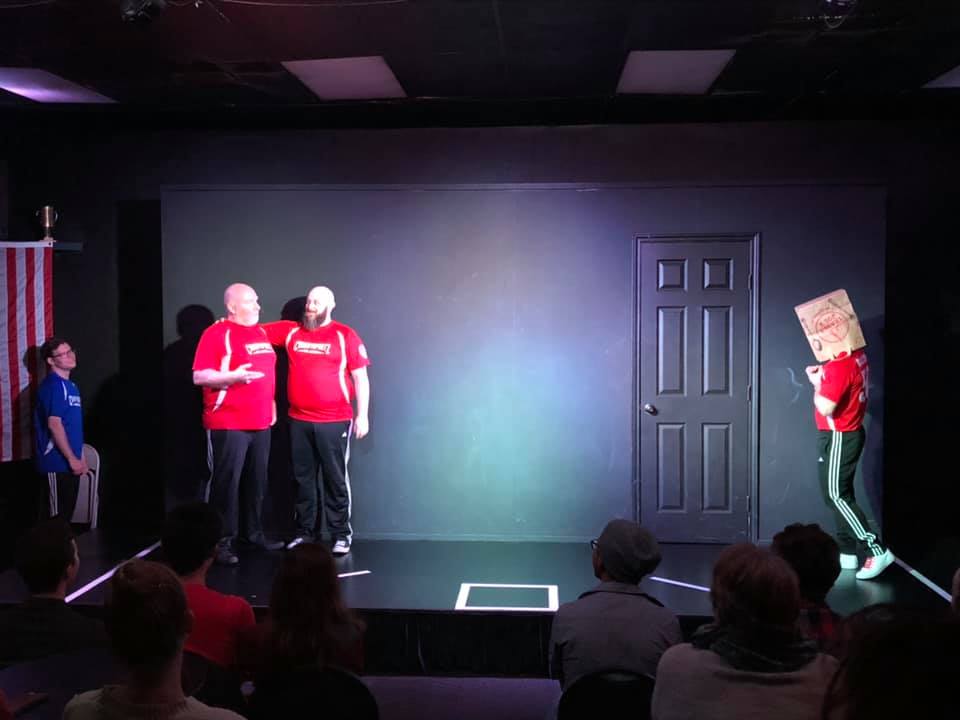 Alan and Brian share a moment while Michael tries to look on, despite the Brown Bag, in Mega Styles Replay at ComedySportz San Antonio